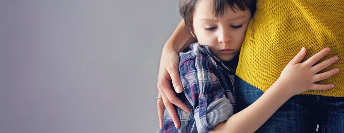 Sad little child, boy, hugging his mother at home